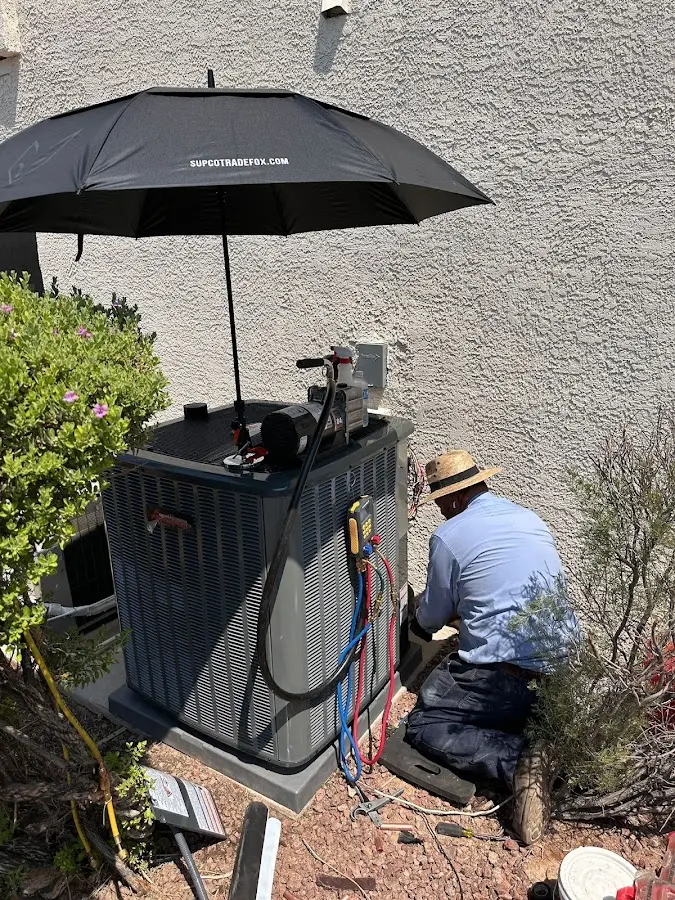 HVAC technician performing outdoor AC maintenance in Monroe